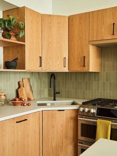 a kitchen with wooden cabinets and stainless steel appliances, including a stove top oven in the center