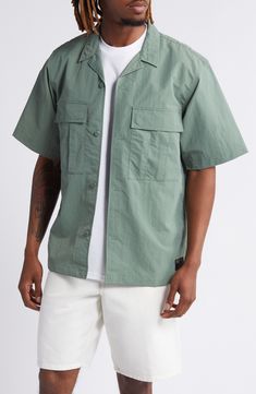 A loose fit gives you room to move comfortably in this workwear-inspired shirt made from durable, adventure-ready nylon ripstop. 29 1/2" length, 44" chest (size medium) Front button closure Notched collar Short sleeves Chest snap-flap pockets 100% nylon Machine wash, line dry Imported Collared Utility Shirt For Outdoor, Khaki Camp Shirt With Pockets For Outdoor, Outdoor Khaki Camp Shirt With Pockets, Cotton Camp Shirt With Pockets For Outdoor Activities, Relaxed Fit Tops With Cargo Pockets For Outdoor, Khaki Cotton Camp Shirt For Outdoor, Relaxed Fit Cotton Camp Shirt For Outdoor Activities, Casual Camp Shirt With Pockets For Outdoor, Outdoor Khaki Cotton Camp Shirt