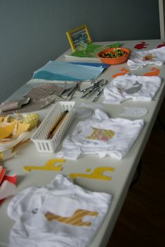 the table is full of baby clothes and other items to be sewn for them