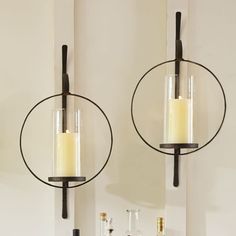 two candle holders are hanging on the wall