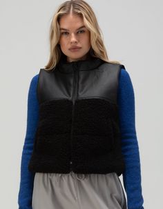 Rsq Faux Leather Sherpa Vest. This Faux Leather Sherpa Vest Offers A Chic Blend Of Textures With Its Stylish Two-Tone Design. The Upper Part Features Sleek Faux Leather For An Edgy Appeal, While The Bottom Half Is Crafted From Plush Sherpa For Added Warmth And Comfort. Perfect For Layering Over Tops And Sweaters, This Vest Adds A Modern, Cozy Touch To Any Outfit. Zipper Front. Welt Hand Pockets. Sherpa Fabric: 100% Polyester. Shell Fabric B: 100% Polyurethane. Dry Clean Only. Imported. Model Is Wearing A Size Small. Model Measurements:height: 5'7" Bust: 32"waist: 25"hips: 35" Overalls Boys, Chino Pants Women, Wwe T Shirts, Sherpa Vest, Graphic Trends, Sherpa Fabric, Casual Flat Shoes, Girls Blouse, Shoes With Jeans