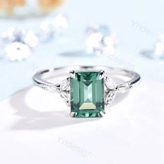 Emerald Cut Green Sapphire Engagement Ring White Gold-14K/18K Vintage Moissanite Wedding Ring For Women Teal Sapphire Anniversary Ring The green sapphire ring is made can be made in white gold,rose gold or yellow gold with 14k or 18k. However for some people who are nickel allergic,I can also make it to 925 sterling silver to make you can wear it.the side stones are moissanites when made in 925 sterling silver Engagement Ring: 6x8 mm emerald cut Lab treated Green Sapphire. Accent stone: Moissani White Emerald Engagement Ring, Green Emerald-cut Sapphire Wedding Ring, Emerald Cut Green Sapphire Wedding Ring, Green Sapphire Wedding Ring Fine Jewelry, Green Sapphire Ring With Round Cut For Wedding, Sapphire Solitaire Ring For Wedding, Wedding Sapphire Ring, Emerald Cut, May Birthstone, Wedding Sapphire Ring With Emerald Cut For May Birthstone, Green Moissanite Emerald Ring For Wedding