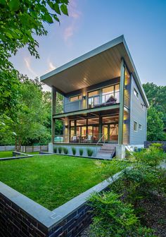 a modern house in the middle of a lush green yard