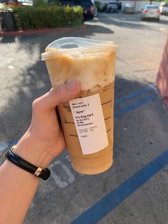 a person holding up a plastic cup with food in it's hand on the street