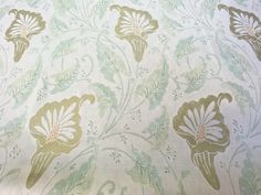 a close up view of a floral pattern on a white fabric with green and yellow flowers