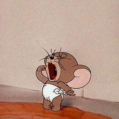 a cartoon character with an open mouth and big ears standing in front of a wall