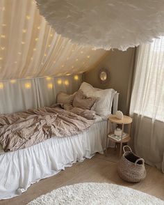 a bed with white sheets and lights on the wall above it, in a bedroom