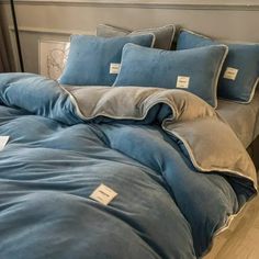 a bed with blue sheets and pillows on it