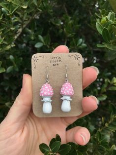 a pair of pink and white mushroom earrings