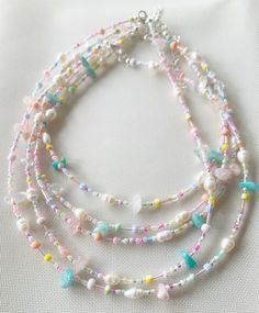 multi - strand beaded necklace with glass beads and pastel colors on white background