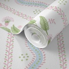 a roll of wallpaper with green and pink flowers on the ground next to it