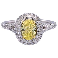 Tiffany & Co. Fancy Yellow engagement ring from the Soleste collection featuring a 1.04 carat oval center ,Fancy Intense Yellow VVS2 clarity finely crafted in platinum, accented by a double row halo and split shank design with round brilliant cut bead set diamonds weighing 0.42 carats D-G color, IF- VS2 clarity. Both stone and ring are inscribed with registered Tiffany Serial numbers. Ring is fully hallmarked with logo, serial numbers and metal content. Ring Specifications Brand: Tiffany & Co. Style: Soleste Hallmarks: Tiffany & Co. PT950 71560597 D 1.04 CT Finger Size: 6 (Can be re-sized) Metal: Platinum Halo Measurements: 11.7mm x 10.2mm Band Width: 2.0 mm Weight: 5.7 grams Current Retail: $27,000 Diamond Specifications Center Diamond Shape: Oval Center Diamond Weight: 1.04 carats Color/ Yellow Engagement Ring, Fancy Yellow Engagement Ring, Oval Diamond Engagement, Yellow Diamond Rings, Yellow Engagement Rings, Oval Diamond Engagement Ring, Bead Set, Split Shank, Yellow Diamond