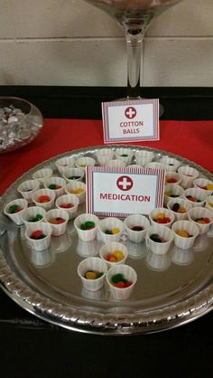 there are many small cups on the table with food in front of them and a sign that says medication