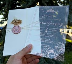 a person holding two wedding cards in their hand