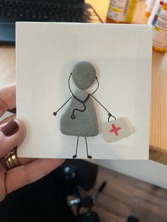 someone holding up a card with a drawing of a person and a heart on it