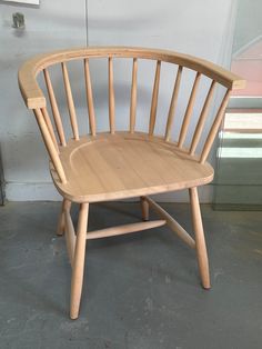 a wooden chair sitting on top of a cement floor