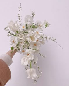 a person holding a bouquet of white flowers