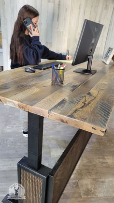 a woman sitting at a wooden table talking on her cell phone