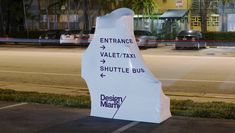 a large white sign sitting on the side of a road