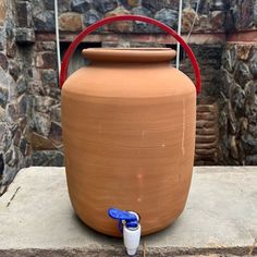 a large clay pot sitting on top of a cement slab