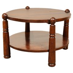 a round wooden table with three legs and two shelves on each side, one shelf is turned upside down