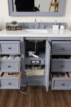 a bathroom vanity with two drawers and a mirror above it that has an electrical outlet plugged into the sink