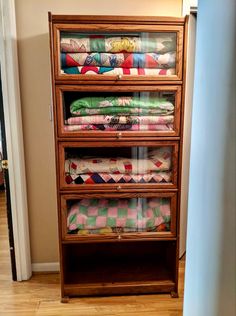 an old dresser with many folded blankets on it