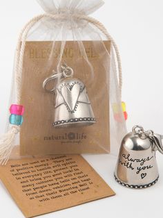 a bell with a message on it sitting next to a bag and notecard holder