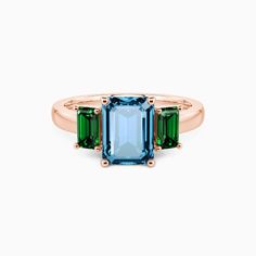 an emerald and green tourmaline ring with two stone accents in rose gold plated brass