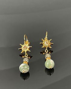 Embrace the sun's radiance with our Quianna Jade Earrings. These exquisite earrings showcase a radiant sun design adorned with a shimmering European crystal for added sparkle. Enhanced with Green Lucky Jade Gemstone, faceted gold Hematite, and Green Tourmilated Quartz, these earrings bring a touch of elegance and luck to any ensemble. Versatile and stylish, they effortlessly elevate your outfit with their captivating charm. Elegant Sunburst Jewelry With Sun And Moon Design, Elegant Sunburst Earrings As A Gift, Elegant Sun And Moon Design Sunburst Jewelry, Elegant Sun And Moon Design Drop Earrings, Elegant Sun Design Drop Earrings, Elegant Sun Design Earrings As Gift, Elegant Dangle Earrings With Sun Design, Elegant Sun Design Dangle Earrings, Black Pearl Bracelet