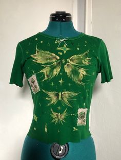 a mannequin wearing a green shirt with flowers on it