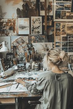 a woman sitting at a desk with lots of art supplies on it's walls