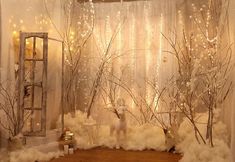 a room filled with fake trees and white fur on the floor next to a window