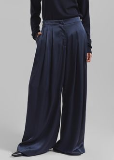 Color: Navy Midweight satiny fabric Relaxed fit Wide leg High rise Pleated front Detachable crossover satin detail on front Center front and back crease Side seam pockets Single back welt pocket Zip fly Hook and bar closure Unlined 86% Triacetate 14% Polyester Machine Wash Cold By JW Anderson. Made in Bulgaria Chic Silk Wide Leg Pants For Work, Chic Silk Pants For Workwear, Satin Wide Leg Pants For Workwear, Chic Satin Tapered Leg Pants, Sleek Silk Pants For Workwear, Sleek Satin Pants For Work, Chic Satin Bottoms For Formal Occasions, Chic Formal Satin Bottoms, Full Length Wide Leg Satin Pants For Work