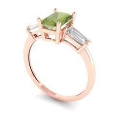 a rose gold engagement ring with an emerald and two baguets on the side