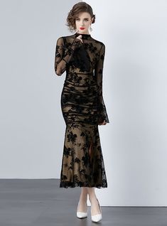 Mystique becomes tangible in this delicately crafted black lace dress that exudes both elegance and sensuality. A sheer overlay with intricate floral patterning cascades over a sleek, form-fitting underlay, creating a dance between concealment and revelation. The full-length sleeves bloom into fluted cuffs, adding a touch of dramatic flair, while the high neckline balances the ensemble with a touch of traditional grace. Perfect for gala events or sophisticated soirées, this dress demands attenti Fitted Lace Dress With Lace Trim For Gala, Fitted Scalloped Lace Evening Dress, Fitted Lace Evening Dress With Scalloped Lace, Fitted Lace Evening Dress With Scalloped Detail, Chic Evening Lace Mesh Dress, Glamorous Fitted Lace Trim Evening Dress, Lace Evening Dress For Night Out, Glamorous Fitted Evening Dress With Lace Trim, Bodycon Lace Dress With Lace Trim For Evening