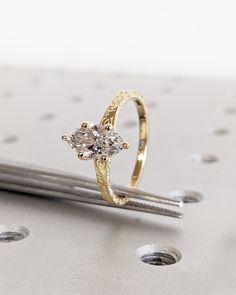 a diamond ring sitting on top of a piece of metal