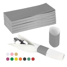 a stack of gray and white napkins next to a pair of scissors with colored markers