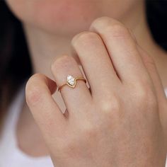 a close up of a person wearing a ring with a diamond on the middle finger