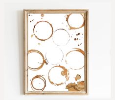 an abstract painting on a white wall with brown circles