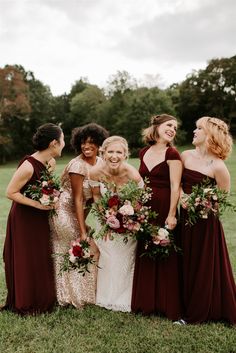 a group of women standing next to each other on top of a lush green field