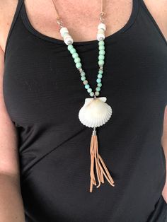 Beautiful Shell Boho style pendant necklace featuring a large white Scallop shell from my personal shell collection. The necklace is 28 inches long and is adjustable. The straps are genuine suede cord with Silver metal accents, Sea Jasper beads, mint green wood beads and shell heishi beads. The shell also matching suede tassel. This is a one of a kind piece and looks great with many colors and styles of clothing. Very versatile. Adjustable Tassel Necklace For Beach, Handmade Tassel Necklace For Beach, White Long Shell Necklace For Beach, White Bohemian Tassel Necklace For Beach, Bohemian White Tassel Necklace For Beach, Beaded Tassel Necklace For The Beach, Handmade Adjustable Tassel Necklace For Beach, Sea Jasper, Beach Lover Gifts