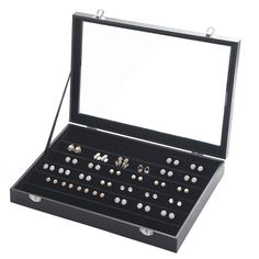 an open jewelry box with several pairs of earrings in it on a white background,