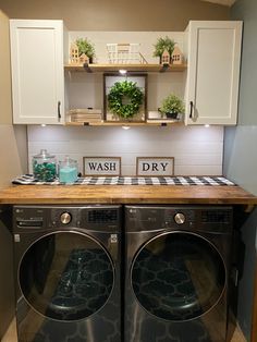 a washer and dryer in a small room with white cupboards on the wall