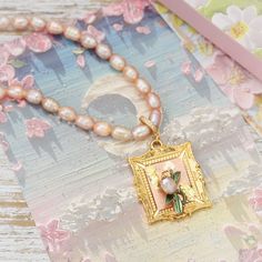 Adorn your neckline with vintage romance wearing this lovely Antique Tulip Necklace with Pink Pearl. Dainty gold-plated metal tulip blooms accented with shimmering pink pearl, exuding an heirloom charm. Each flower possesses uniquely aged character and finely preserved detailing that transports the wearer's sentiments to days past. This meaningful necklace lends subtle flair and timeless beauty to both everyday and special occasion looks with its blend of the antique and elegant in pink pearl. D Elegant Vintage Charm Necklace For Mother's Day, Elegant Vintage Charm Necklaces For Mother's Day, Vintage Gold Pearl Necklace Gift, Vintage Necklaces With Flower Charm For Mother's Day, Gold Feminine Flower Necklace For Wedding, Feminine Gold Flower Necklace For Wedding, Vintage Pink Pearl Necklace, Vintage Gold Flower Necklace, Vintage Gold Flower Necklace For Wedding