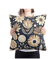 a woman holding a pillow with flowers on it