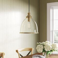 a dining room table with flowers on it and a light fixture hanging over the table