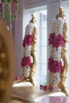 the mirror is decorated with pink and white flowers