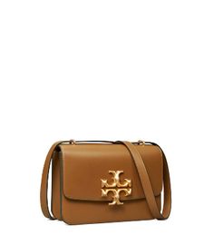 Directly from Tory Burch - Extraordinary craftsmanship in focus. A structured shape in soft Italian leather with hand-painted edges that emphasize the clean lines. Signature hardware, scaled-up in sculptural brass. The convertible strap lets you carry it on the shoulder or crossbody. Tory Burch Official Site. Designer Satchel Bag For Shopping, Designer Satchel Flap Bag For Shopping, Designer Bags With Removable Pouch For Shopping, Designer Crossbody Bag With Removable Pouch, Luxury Tan Bag For Shopping, Designer Tan Bags With Detachable Handle, Designer Tan Bag With Detachable Handle, Luxury Tan Satchel Bag, Designer Tote Bag With Gold-tone Hardware