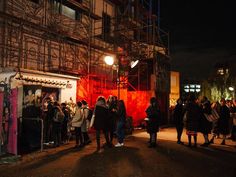 a group of people standing in front of a building with scaffolding on it